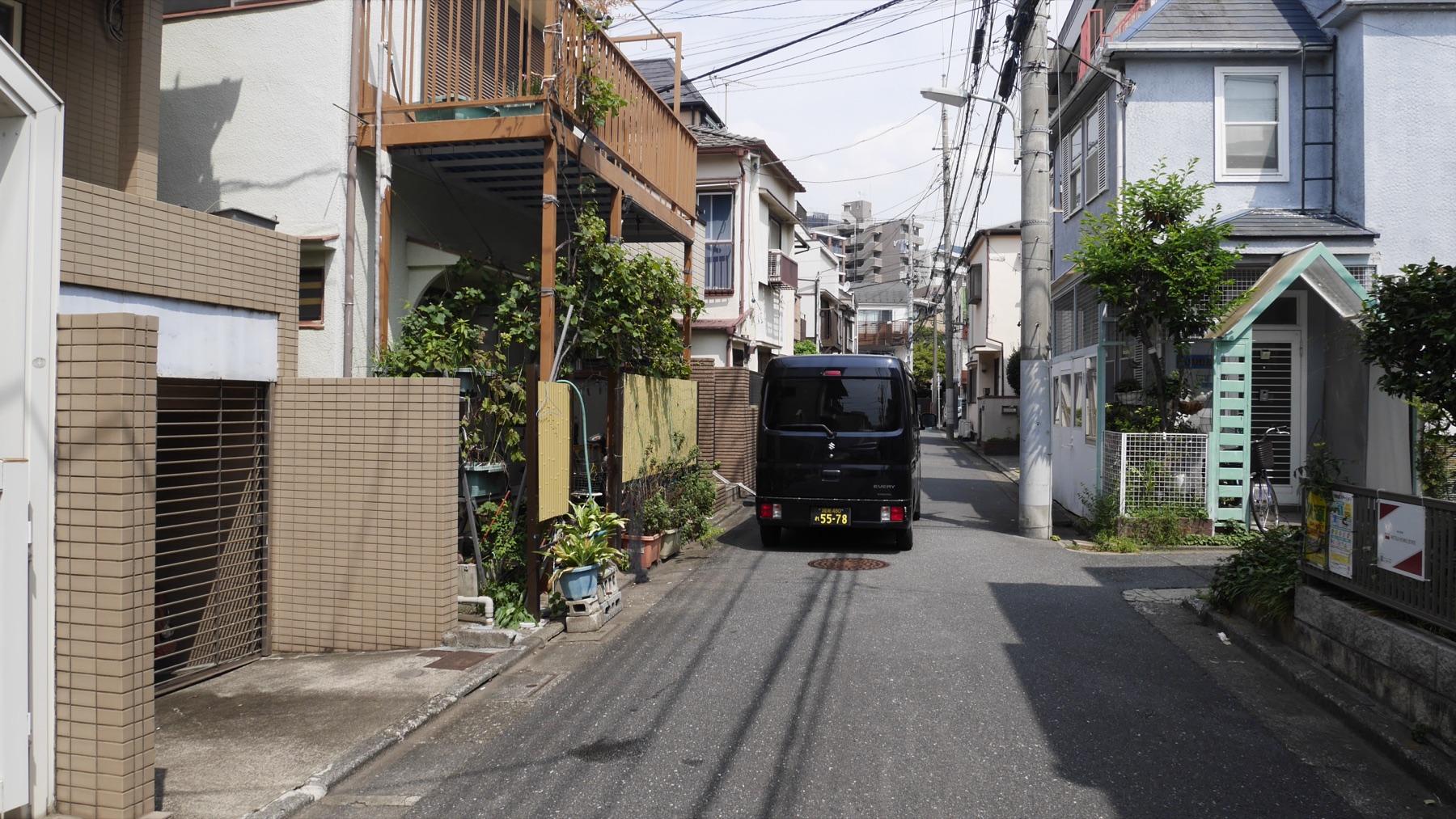 住宅街の細い道に停まる軽バン