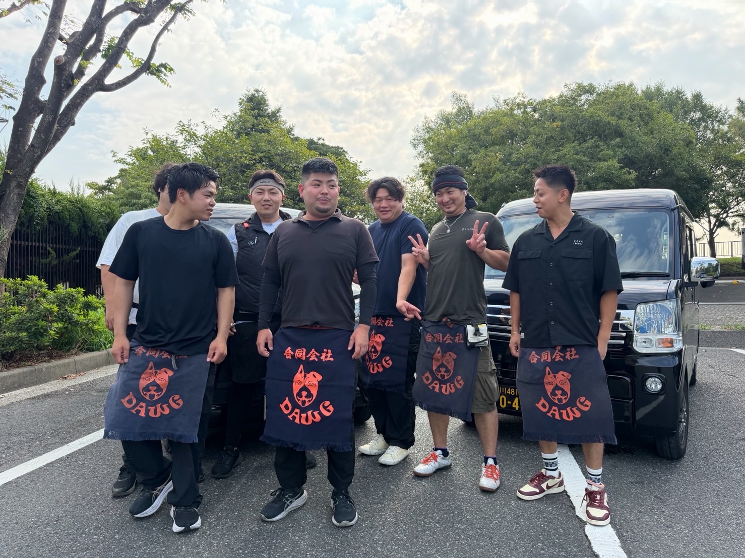 拠点の駐車場に並ぶ軽バンとドライバー